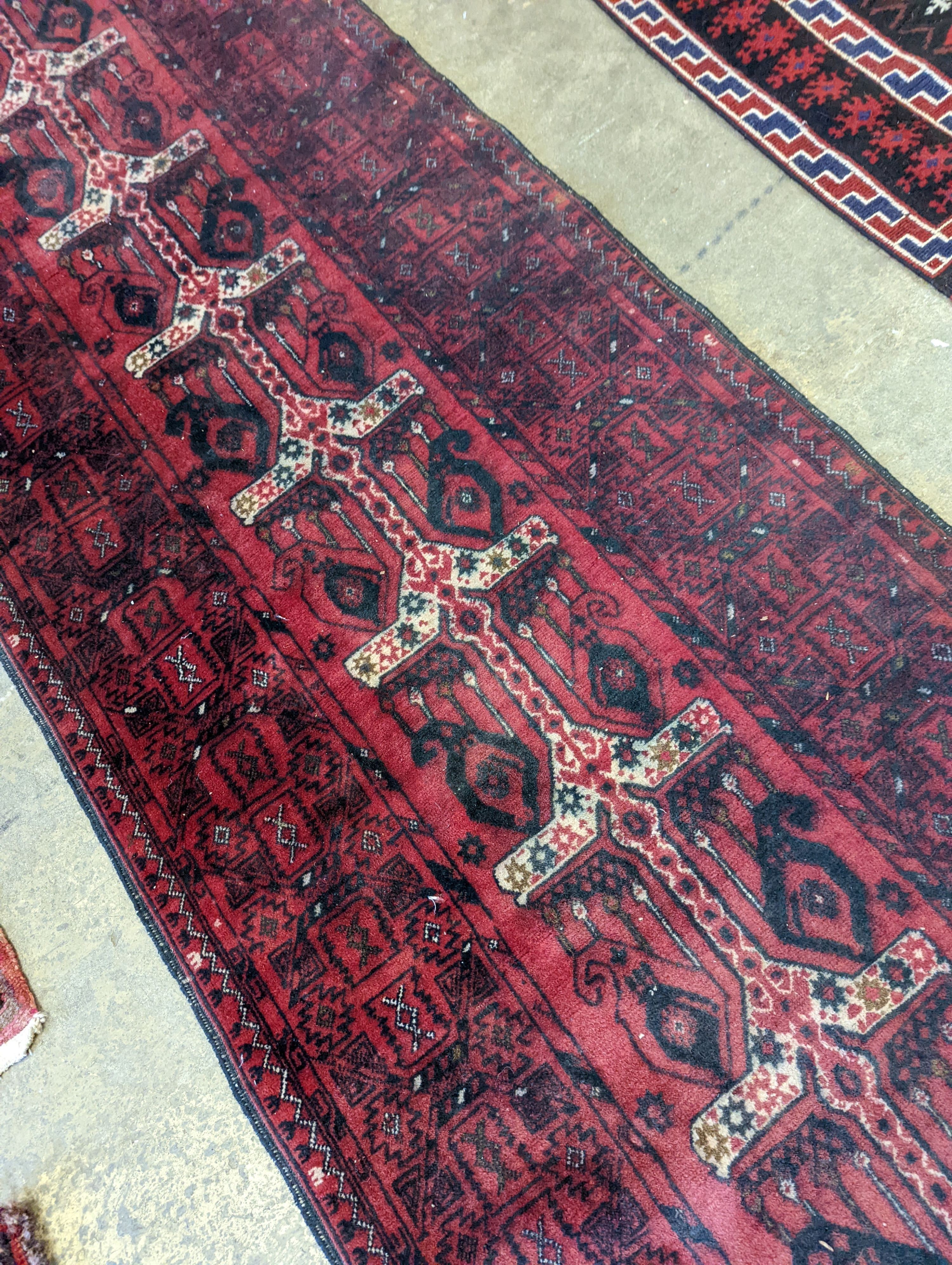 A Belouch red ground runner, 274 x 77cm